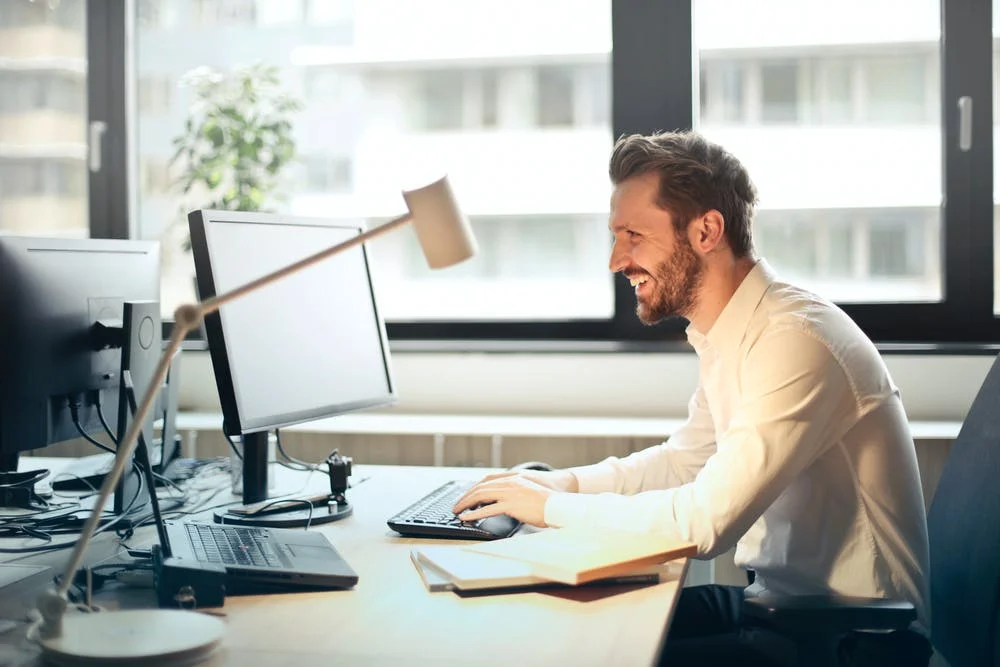 Smiling professional at computer in Ridlin office